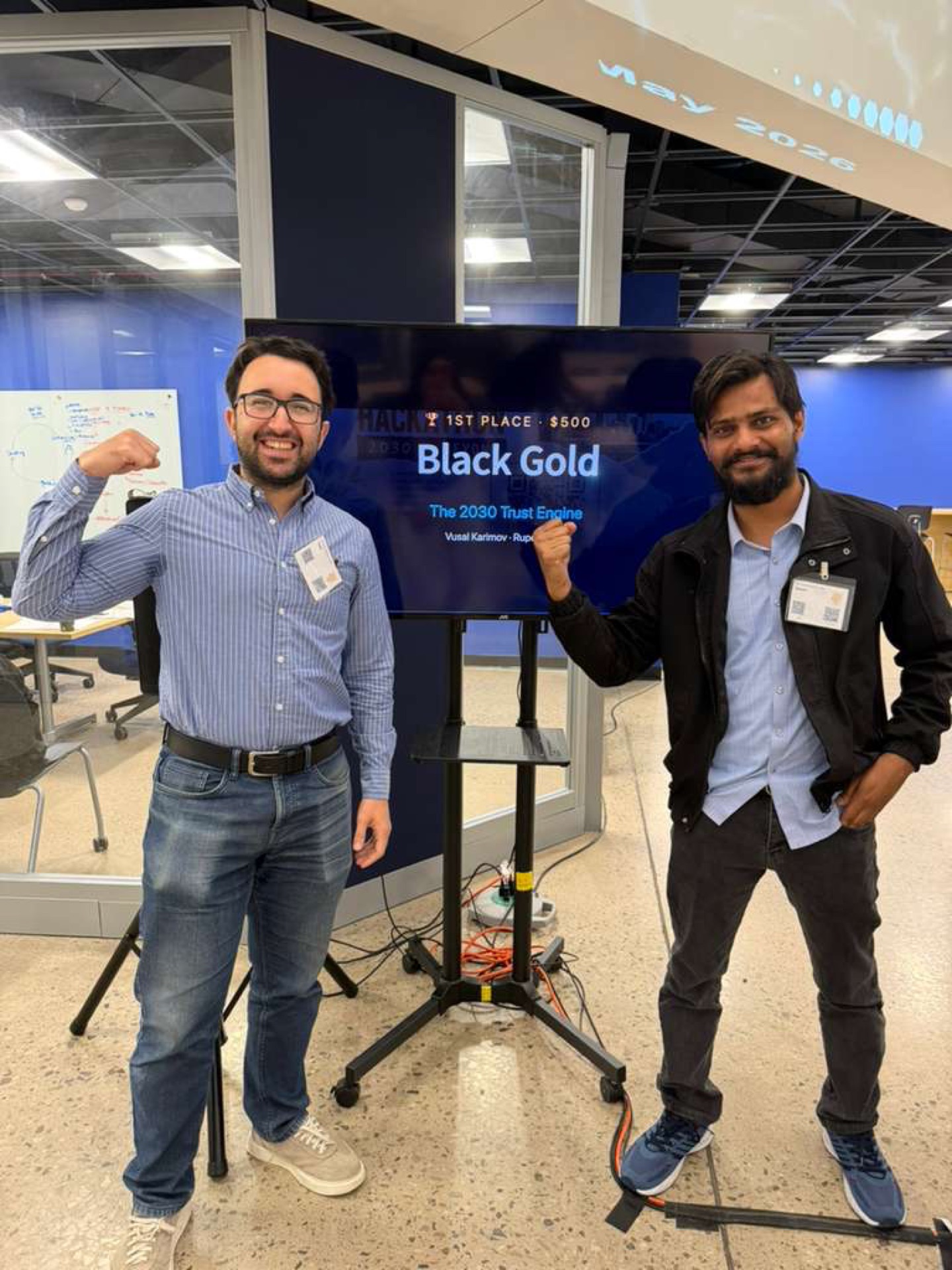 Two hackathon winners celebrating in front of their first-place slide
