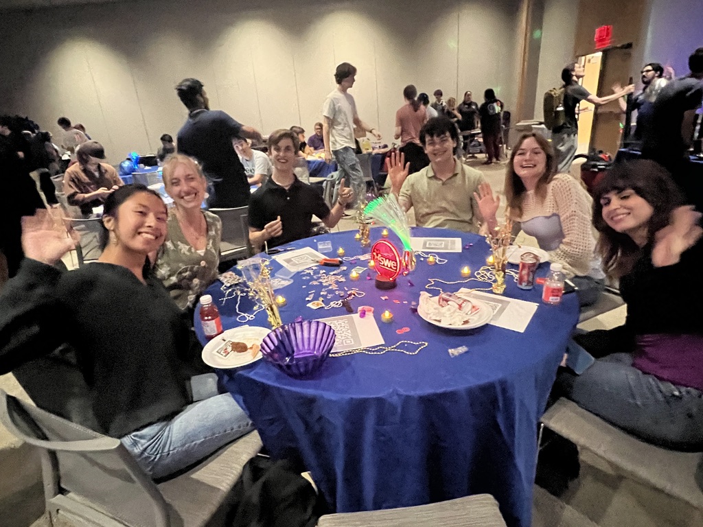 Students waving from the Society of Women Engineers table